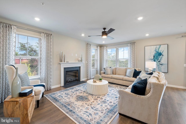 living room featuring a healthy amount of sunlight, ceiling fan, and dark hardwood / wood-style flooring