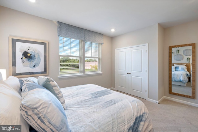 bedroom featuring light carpet and a closet