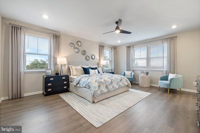 bedroom with wood-type flooring, multiple windows, and ceiling fan