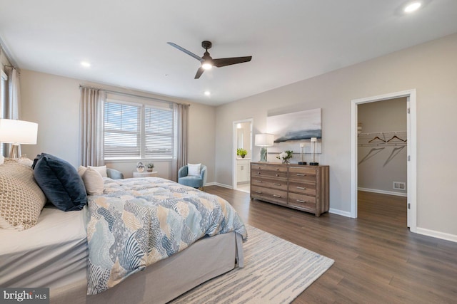 bedroom with ceiling fan, a closet, dark hardwood / wood-style floors, and a spacious closet