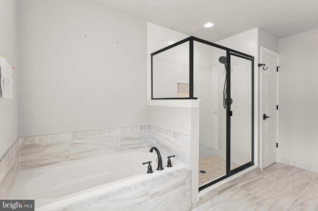 bathroom featuring shower with separate bathtub