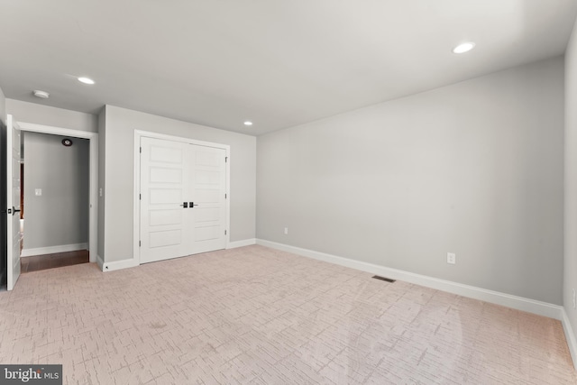 unfurnished bedroom with light colored carpet and a closet