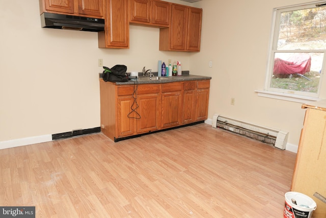 418 Center Ave, Jim Thorpe, PA 18229 - kitchen with under cabinet range hood, a baseboard heating unit, light wood-type flooring, and brown cabinetry