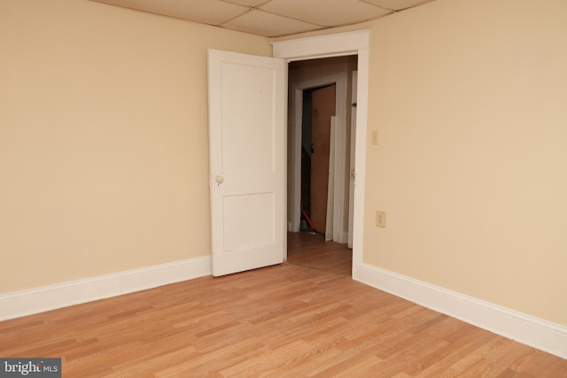 unfurnished room with a paneled ceiling and light hardwood / wood-style flooring