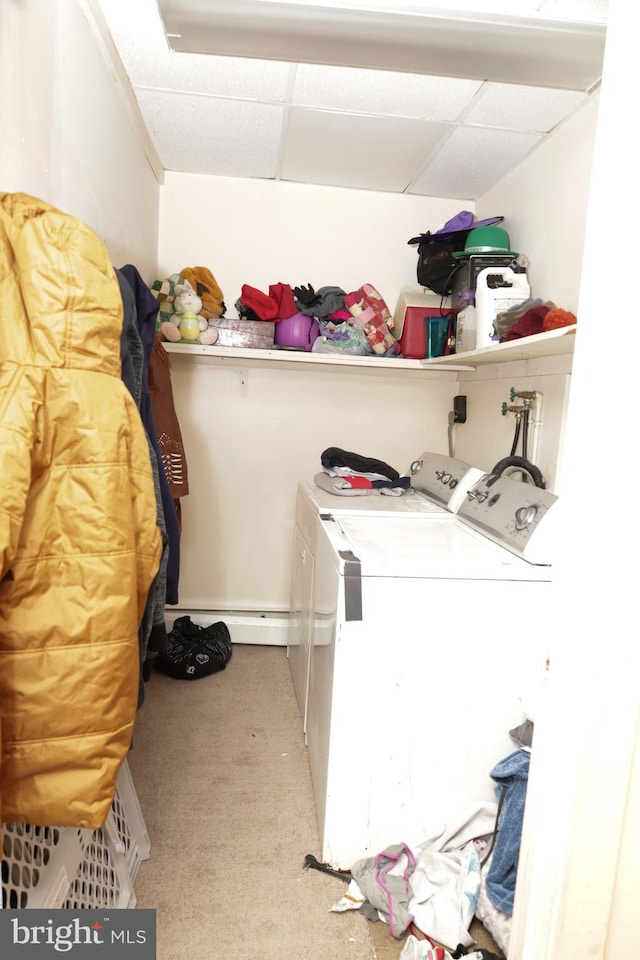 washroom with carpet floors, washer and dryer, and a baseboard heating unit