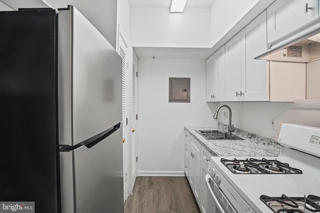 kitchen featuring sink, dark hardwood / wood-style floors, white gas range, white cabinetry, and stainless steel refrigerator