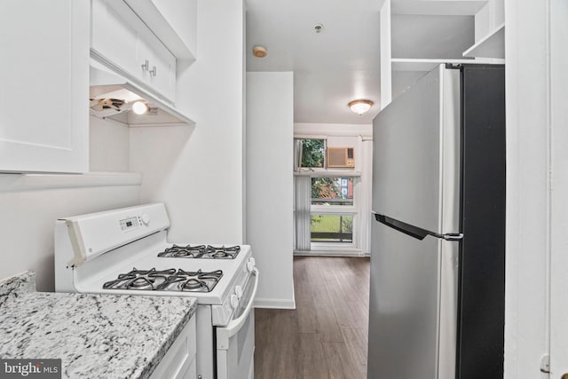 kitchen featuring stainless steel fridge, white cabinets, light stone counters, white range with gas stovetop, and dark hardwood / wood-style floors