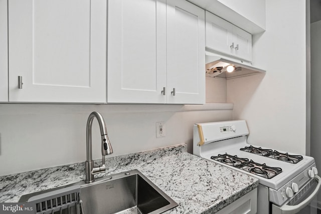 kitchen featuring light stone counters, white cabinetry, sink, and white range with gas cooktop