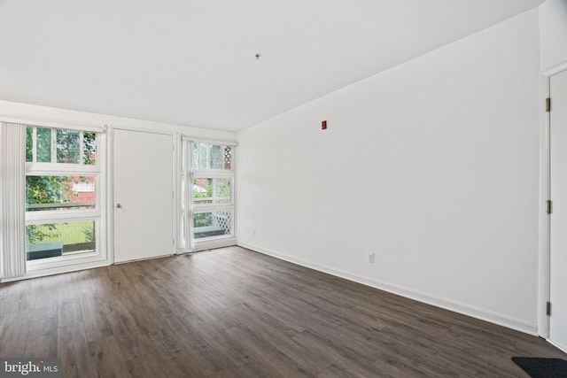 unfurnished room with dark wood-type flooring