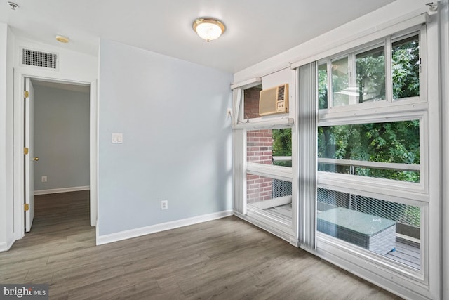 empty room with hardwood / wood-style flooring and a wall mounted AC