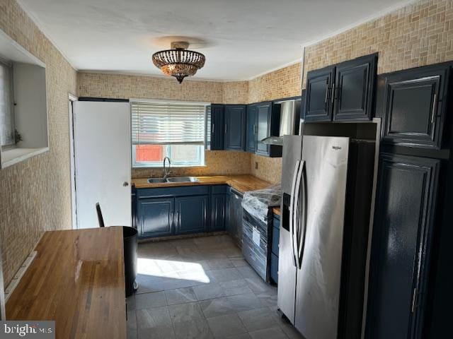 kitchen featuring ventilation hood, stainless steel appliances, blue cabinets, and sink