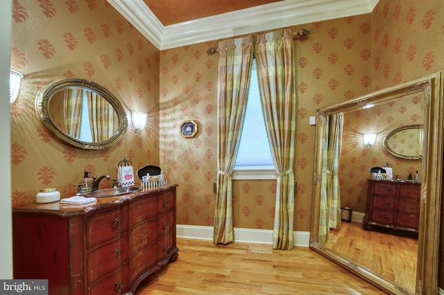 sitting room with ornamental molding, sink, and light hardwood / wood-style flooring