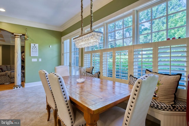 dining space with decorative columns and ornamental molding