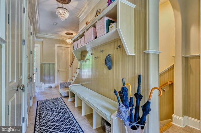 mudroom with ornamental molding, light tile patterned flooring, and a notable chandelier