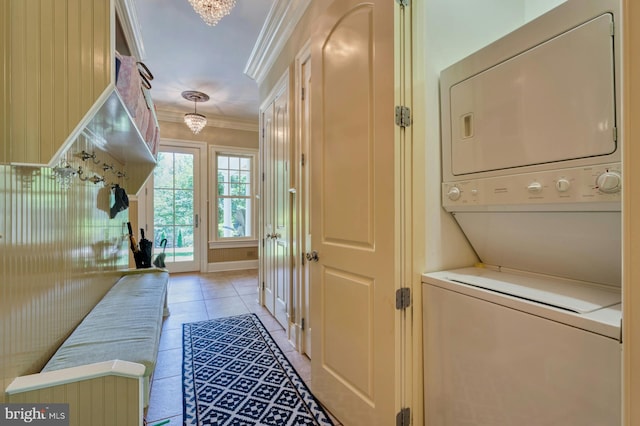 mudroom featuring stacked washer and dryer, crown molding, and light tile patterned floors