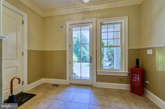 entryway with ornamental molding, light tile patterned flooring, and wood walls