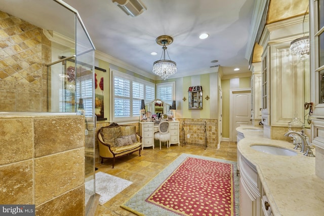 bathroom featuring ornamental molding, a shower with door, vanity, and a notable chandelier