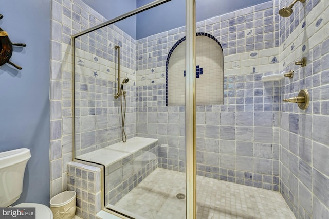 bathroom with a shower with door and toilet