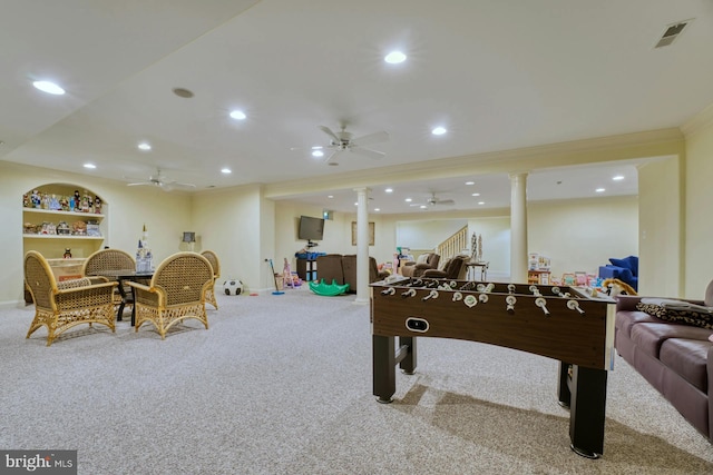 rec room with ornate columns, ornamental molding, carpet flooring, built in features, and ceiling fan