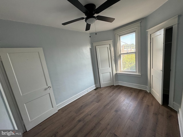 unfurnished bedroom featuring ceiling fan and dark wood-type flooring