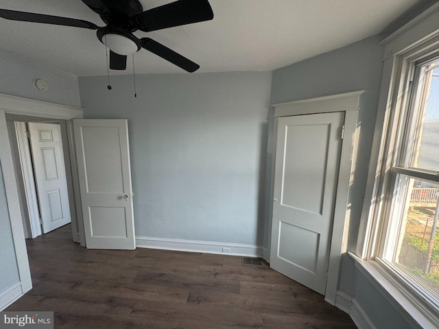 unfurnished room with ceiling fan, a healthy amount of sunlight, and dark hardwood / wood-style flooring