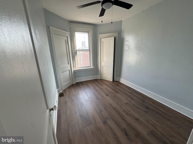 unfurnished room with ceiling fan and dark hardwood / wood-style flooring