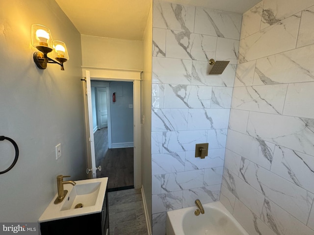 bathroom with wood-type flooring, tiled shower / bath combo, and vanity