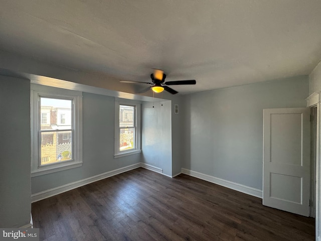 spare room with ceiling fan and dark wood-type flooring