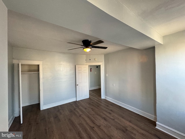 unfurnished bedroom with a closet, ceiling fan, and dark wood-type flooring