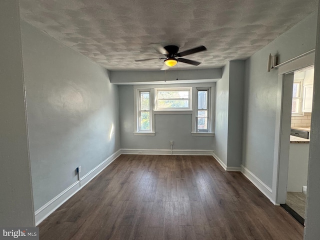 empty room with ceiling fan and dark hardwood / wood-style floors