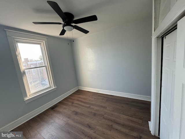 unfurnished bedroom featuring dark hardwood / wood-style floors, ceiling fan, and a closet