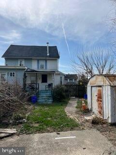 rear view of property featuring a shed