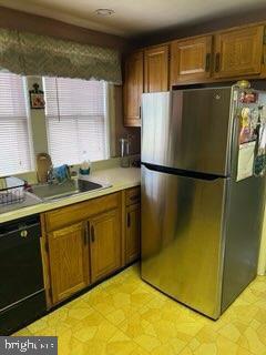 kitchen with sink, dishwasher, and stainless steel refrigerator