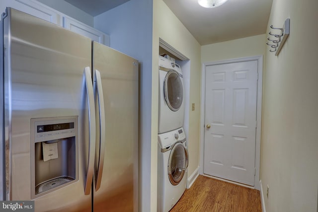 laundry area with light wood-type flooring and stacked washer and clothes dryer