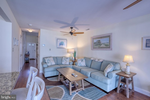 living room with ceiling fan and dark hardwood / wood-style flooring