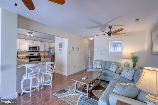 living room featuring ceiling fan and hardwood / wood-style floors