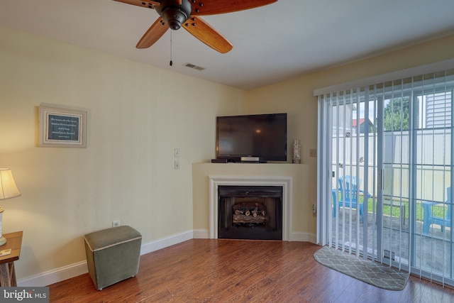 living room with wood-type flooring and ceiling fan