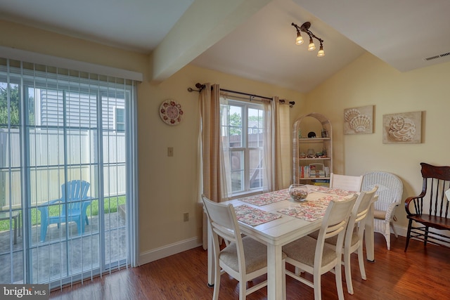 dining area featuring lofted ceiling and dark wood-type flooring