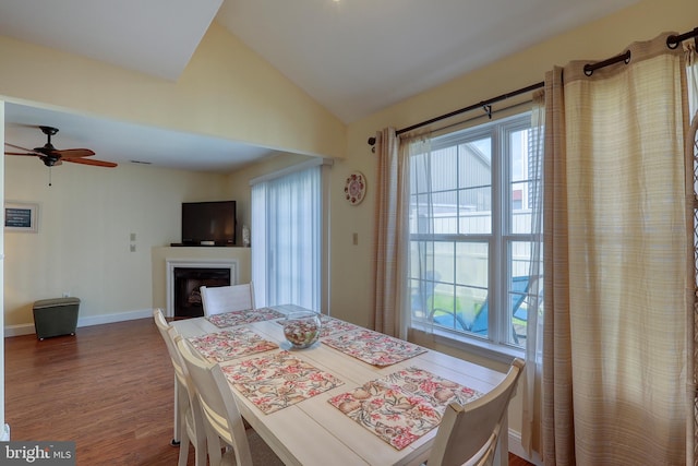 dining room featuring wood-type flooring, vaulted ceiling, and ceiling fan