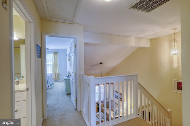 corridor with lofted ceiling with beams and light colored carpet