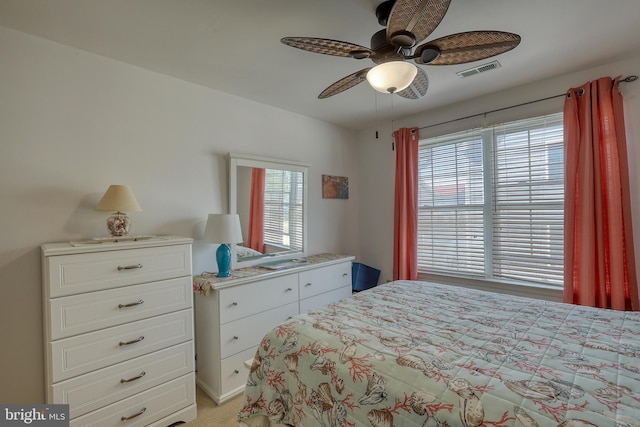 bedroom featuring multiple windows, ceiling fan, and light colored carpet