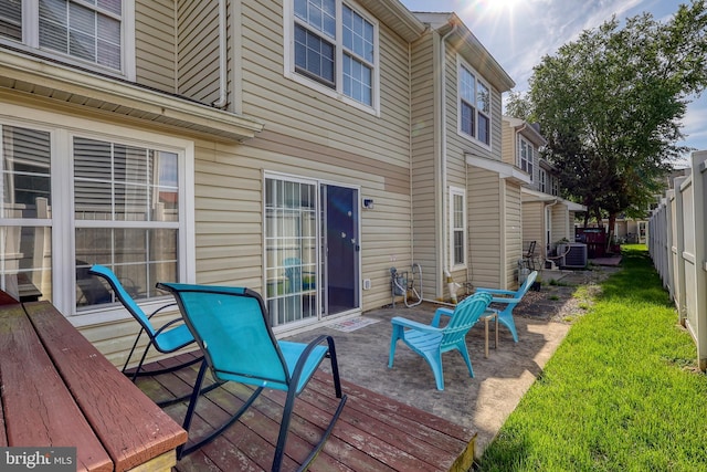 wooden deck with a lawn and central air condition unit