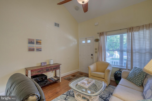 living room with high vaulted ceiling, ceiling fan, and hardwood / wood-style flooring