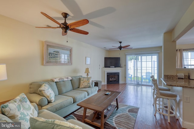 living room featuring wood-type flooring and ceiling fan