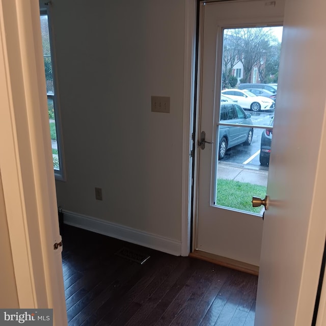 doorway to outside with plenty of natural light and dark wood-type flooring