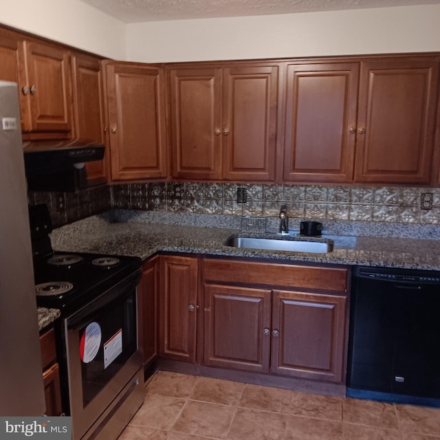 kitchen with appliances with stainless steel finishes, backsplash, sink, and dark stone counters