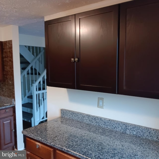 kitchen with dark brown cabinets and a textured ceiling