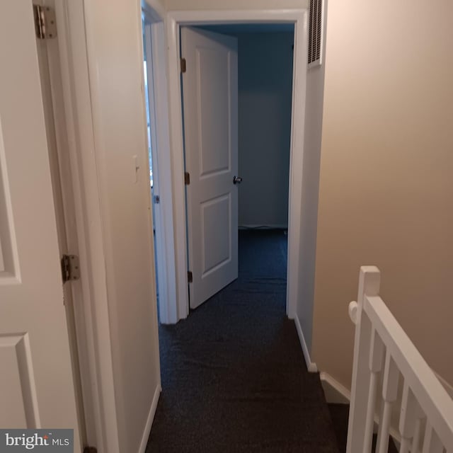 hallway featuring dark colored carpet