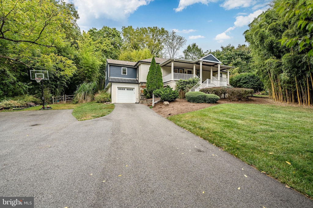 view of front of house featuring a front yard, a garage, and a porch