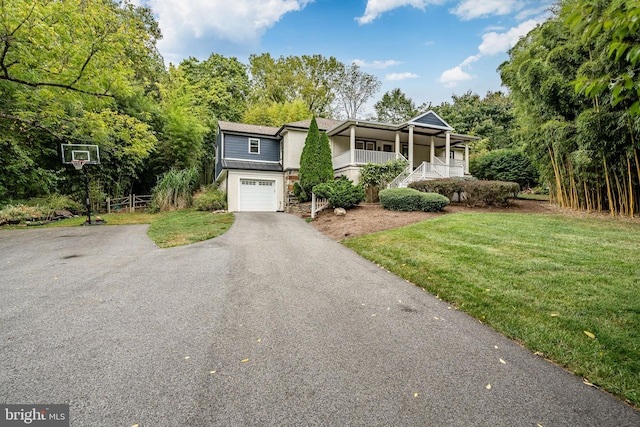 view of front of house featuring a front yard, a garage, and a porch